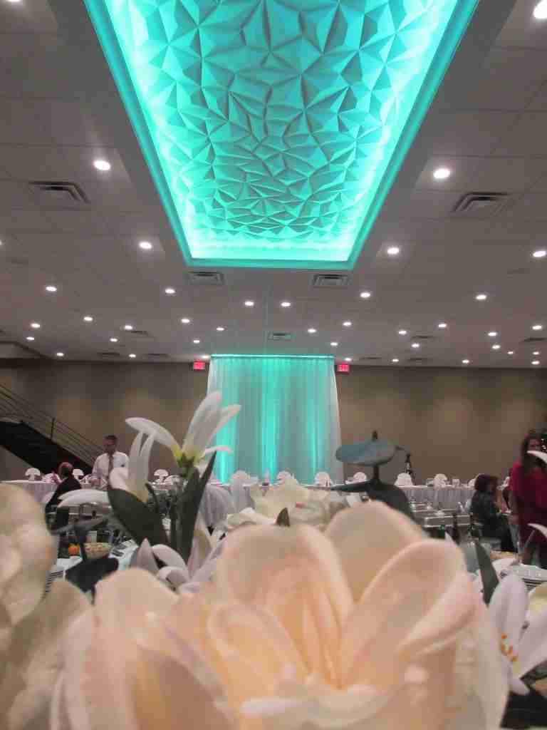 Close up of floral arrangements with teal lighting in Balconade Room