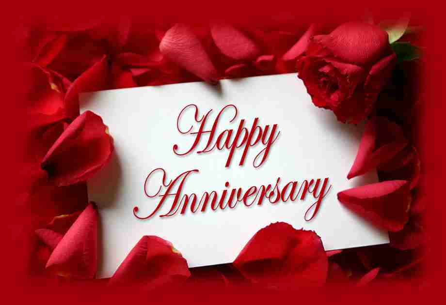 Happy Anniversary written on white card and surrounded by red flower petals for anniversary parties