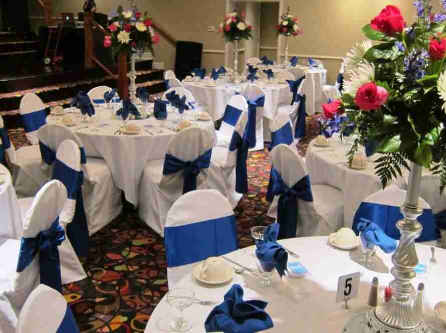 Terrace Room blue chair sashes and linen napkins with red rose centerpieces