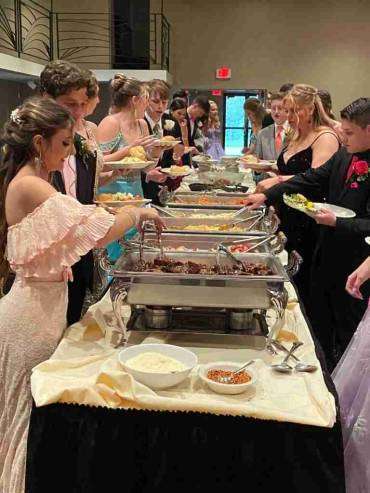 high school students visit the buffet table for their school prom