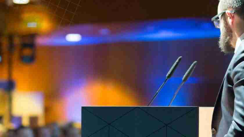 Speaker presenting to audience at an event venue