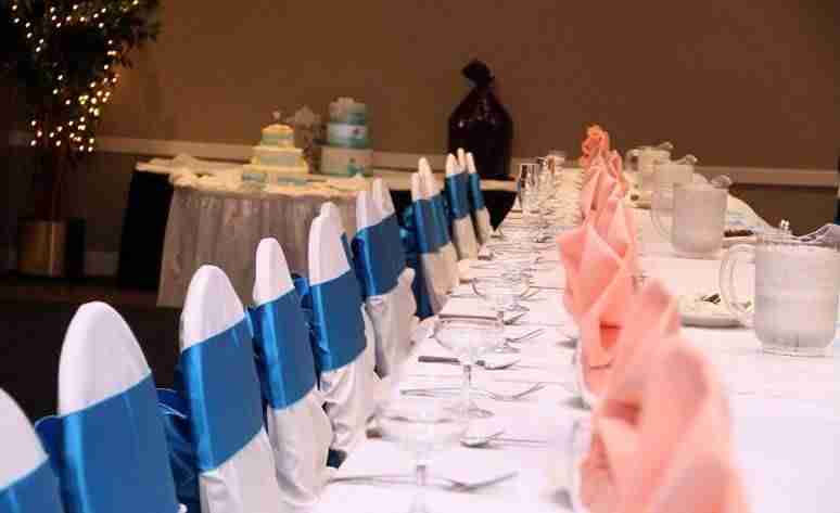 head table of wedding with chair covers and blue sashes