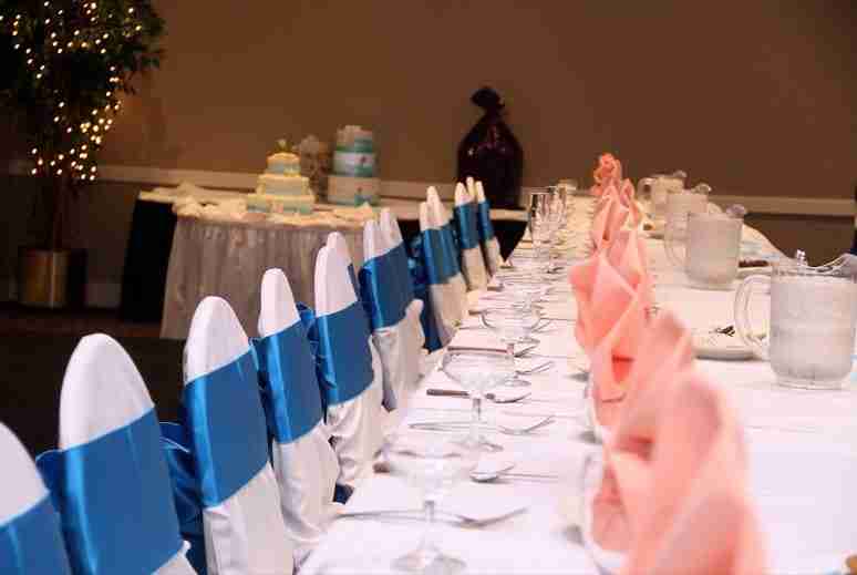 head table of wedding with chair covers and blue sashes